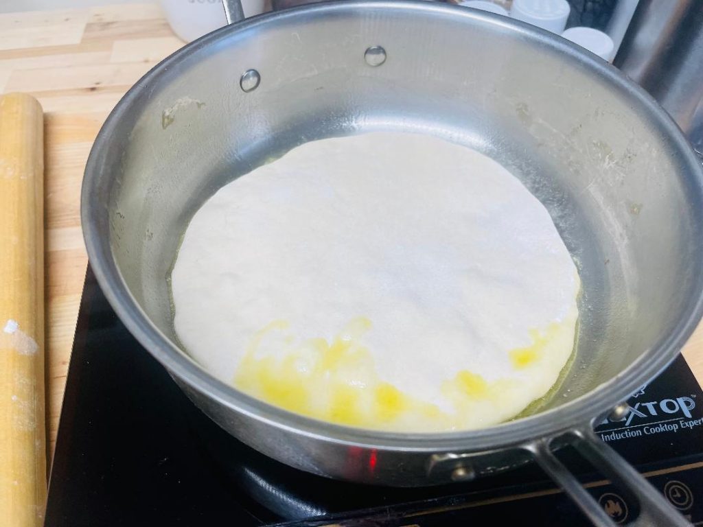 Homemade Pita Bread Recipe: Soft, Fresh & Ready in 90 Minutes 13 pita bread puffing up in skillet