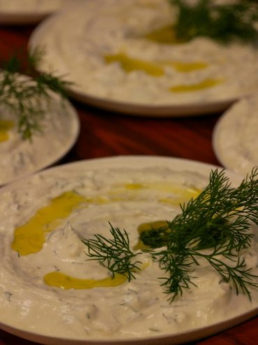 Creamy homemade tzatziki dip in a bowl, garnished with fresh dill and a drizzle of olive oil