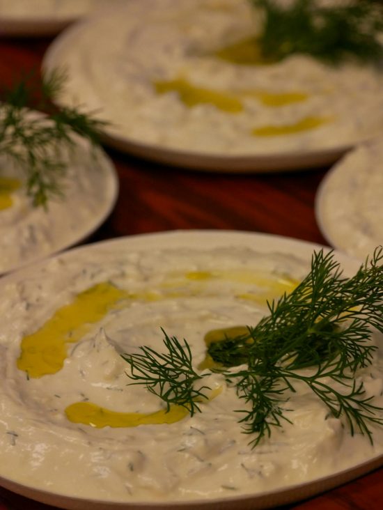 Creamy homemade tzatziki dip in a bowl, garnished with fresh dill and a drizzle of olive oil